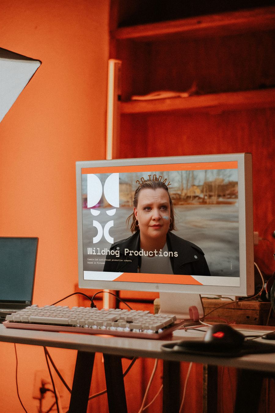 Wildhog Productions homepage on a desktop monitor with the logo and brand graphics
